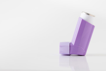 purple asthma inhaler on white background