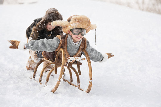 Children Slide Down Hills On Sleds