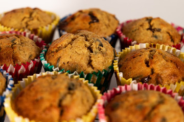 Banana chocolate chip muffin on white background, with shallow depth of field.