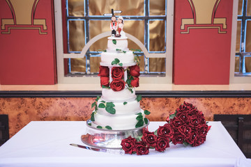 Wedding cake with red rose decoration and cake topper