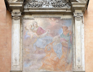 Our Lady holding the Christ Child and seated on the clouds, with Saints Peter and Paul looking on in adoration Church of San Giovanni della Pigna, Rome, Italy