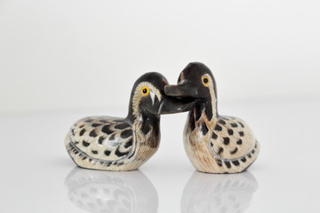 Valentine's day concept. Couple in love, just married or honeymoon concept. Couple of stone mandarin ducks toy with reflection.