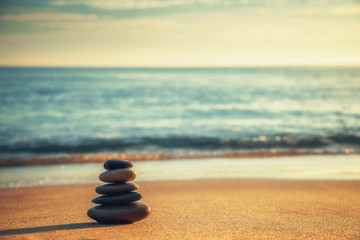 Stones balance on the beach at sunrise, zen meditation