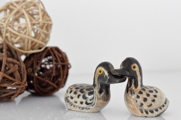 Valentine's day concept. Couple in love, just married or honeymoon concept. Couple of stone mandarin ducks toy with decor and reflection.