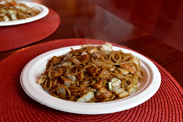 Asian noodles with vegetables and chicken served on plate.