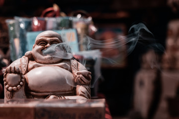 Front view of the iconic Smoking Buddha. Macro shot close up of smoke floating out of the mouth....