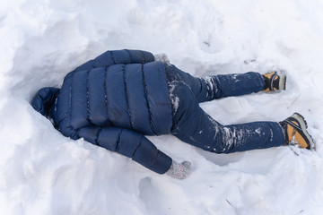 A man lies in the snow, head in a snowdrift