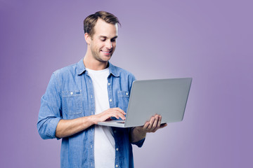 Smiling young man working with laptop