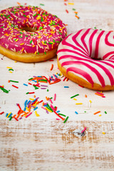 Fototapeta na wymiar Pink donuts on a wooden background.