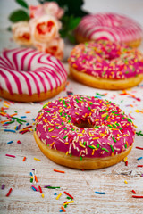 Pink donuts on a wooden background.