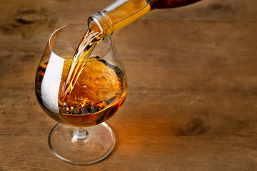 brandy or cognac pouring into glass