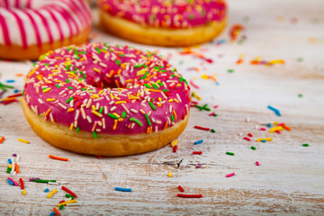 Pink donuts on a wooden background.