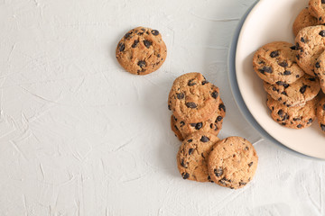 Plate with tasty chocolate chip cookies  on gray background, top view. Space for text
