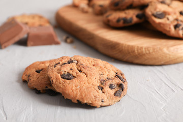 Tasty homemade chocolate chip cookies on gray background