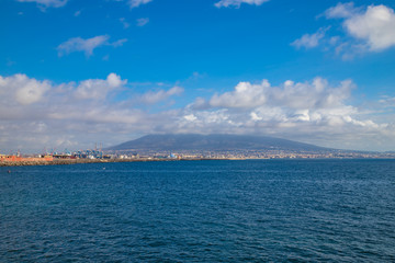 Fototapeta na wymiar Port of city of Naples with Vesuvius vulcan in background with cloudy blue sky, Napoli Italy