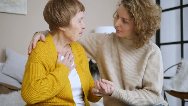 Young Woman Taking Care Of Her Grandmother At Home.