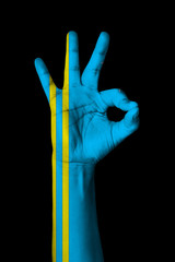 Hand making Ok sign, Aruba flag painted as symbol of best quality, positivity and success - isolated on black background