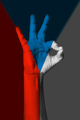 Hand making Ok sign, Czech republic flag painted as symbol of best quality, positivity and success - isolated on flag background