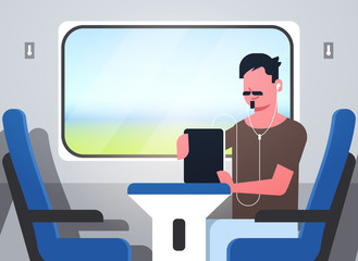 man train passenger listening audio book with headphones stylish guy sitting blue armchair railway traveling concept male character portrait horizontal