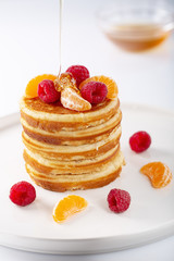Fresh homemade pancakes with raspberry fruits and honey