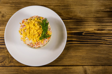 Traditional russian salad Mimosa on wooden table