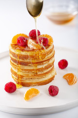 Fresh homemade pancakes with raspberry fruits and honey