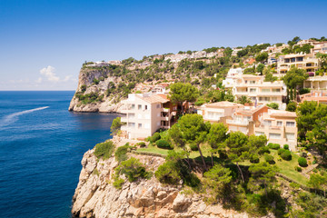 Fototapeta na wymiar Aerial view of villas residences on cliffs and clear blue green water bay Cala Marmassen Mallorca Spain