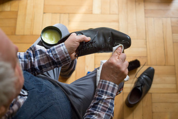 Man hands cleaning his shoes with a rag and shoe wax fot better condition of his shoes, polishing...