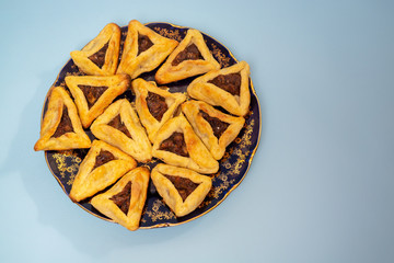 Hamantaschen cookies at the bakery for Purim celebration on blue background.