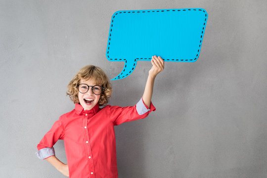 Happy child holding paper speech bubble