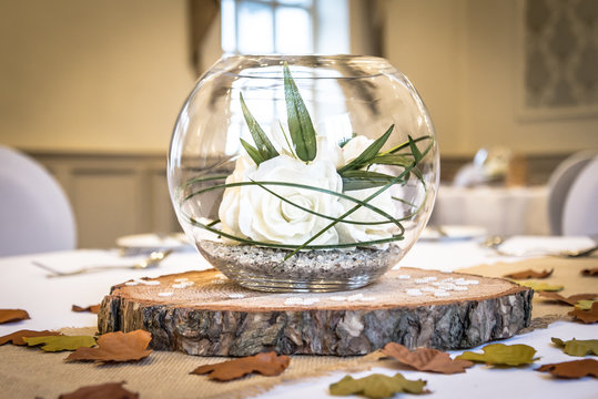 wedding table centrepiece with white roses in a glass bowl