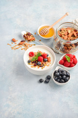Homemade granola with yogurt and fresh berries, healthy breakfast concept.