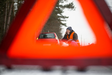 man calling the roadside service / assistance after his car has broken down, car problem concept during winter time