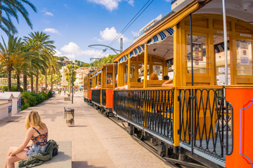 Famous old train in Port de Soller in Mallorca full of motor boats and buildings on cliffs