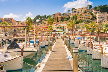 Beautiful Port de Soller in Mallorca full of motor boats and buildings on cliffs - obrazy, fototapety, plakaty