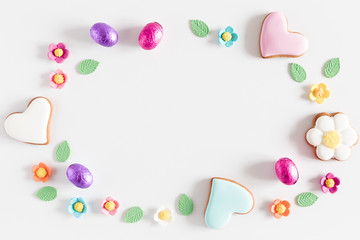 Easter eggs, cookies, sweets, easter decorations on white background. Minimum Easter holiday...