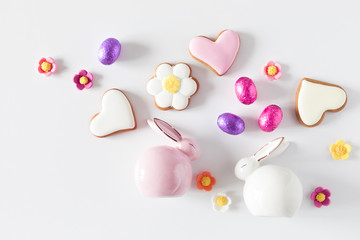 Easter eggs, cookies, sweets, porcelain rabbit, easter decorations on white background. Minimum Easter holiday concept. Flat lay, top view, copy space