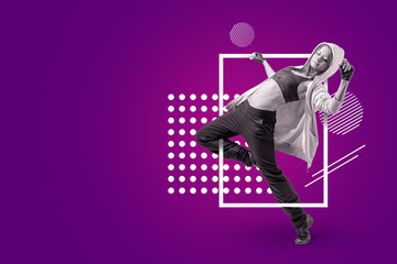 A young beautiful female dancer in sleeveless crop top, sweatpants and hoodie dancing on a purple background with white circular and rectangular shapes.