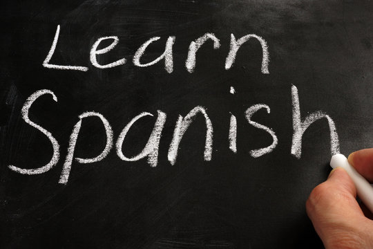 Learn Spanish handwritten sign on a blackboard.