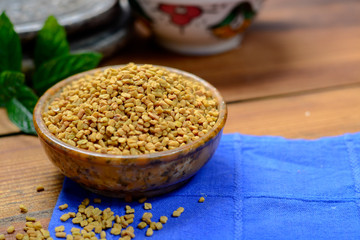 Bowl with fenugreek seeds close up, used for cooking and traditinal medicine, spices collection
