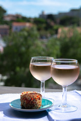 Naklejka premium Rose wine of Provence, France, served cold with soft goat cheese on outdoor terrace in two wine glasses
