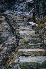 Ancient stone stairs going up on black rock, mountain stairway. Norway, Trolls road, Trollstigen.