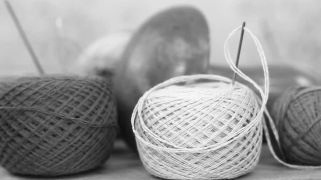 Various threads, needles and the wooden  mushroom for manual darning,  black and white