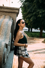 Brunette girl in a summer day in the city wearing round sunglasses