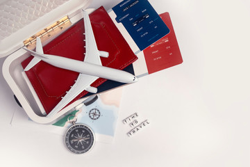 Time to Travel. Idea for tourism with an airplane, suitcase, passport and tickets, compass and map on a light background. Concept on the theme of flights.