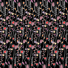 Floral seamless pattern with hand-drawn stylized small flowers and branches on warm colors on black background in doodle style. Botanical endless dark texture. Textile design illustration.