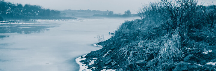 Frozen pond, thaw. Winter season in the countryside.