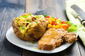 roasted pork chop and potatoes with stuffed skin