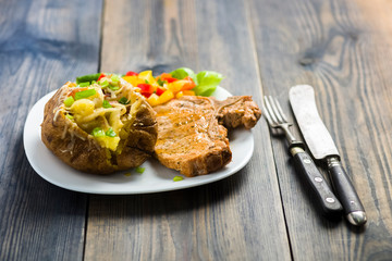 roasted pork chop and potatoes with stuffed skin