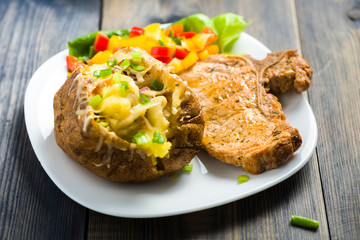 roasted pork chop and potatoes with stuffed skin